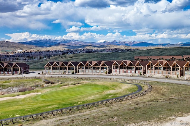 view of home's community featuring a mountain view, view of golf course, and fence