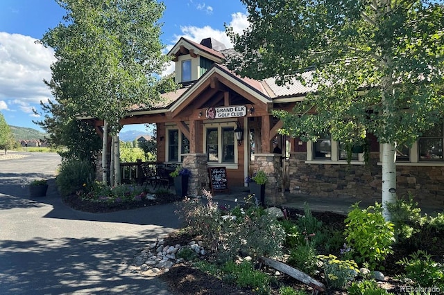 craftsman-style home with covered porch and stone siding