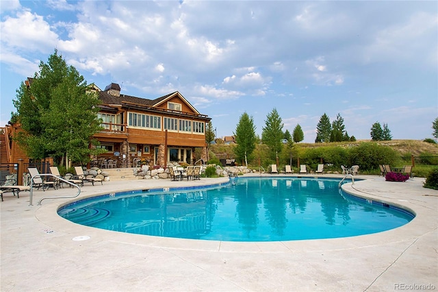 community pool featuring a patio area and fence