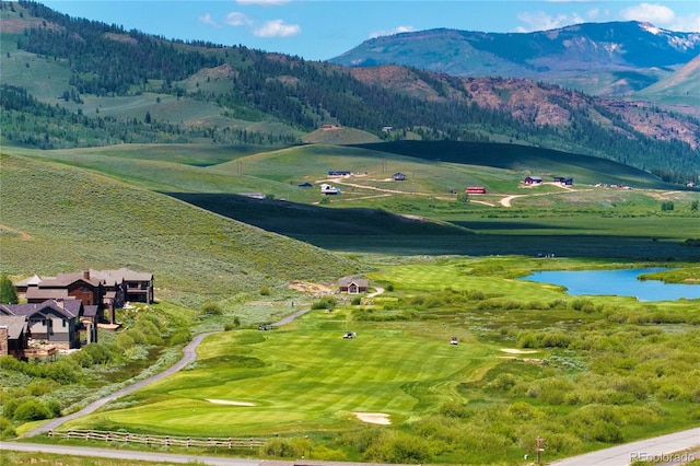 view of mountain background featuring a large body of water and a golf course