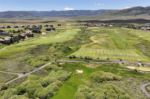 drone / aerial view with view of golf course, a mountain view, and a residential view