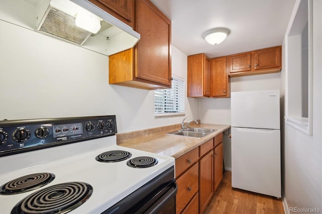 5549 S Greenwood St, Littleton, CO 80120 - kitchen with electric range, freestanding refrigerator, a sink, range hood, and brown cabinetry