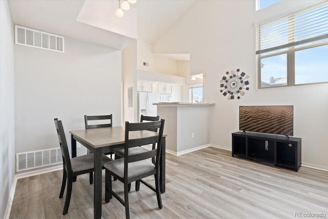 18661 E Water Dr Unit F, Aurora, CO 80013 - dining area featuring light wood-type flooring, plenty of natural light, and a high ceiling