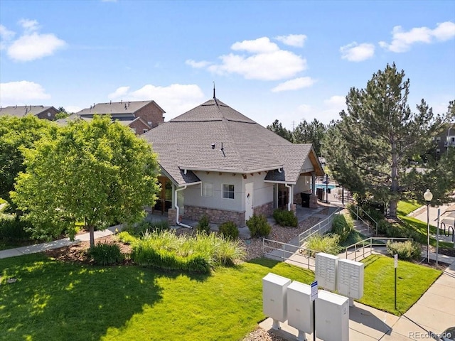 18661 E Water Dr Unit F, Aurora, CO 80013 - view of front facade with stone siding, a front yard, and roof with shingles