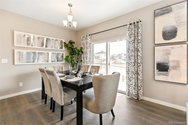 dining space with dark wood-type flooring and a notable chandelier