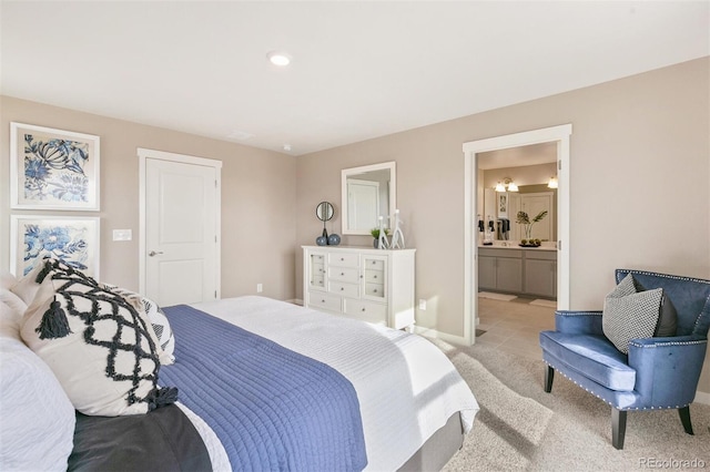 bedroom featuring light carpet and ensuite bath