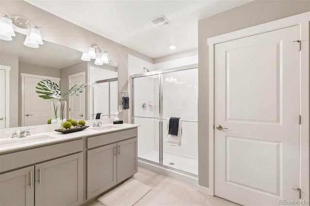 bathroom featuring tile patterned flooring, vanity, and a shower with shower door