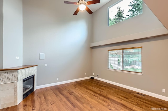 1616 Cedarwood Dr, Longmont, CO 80504 - unfurnished living room featuring ceiling fan, healthy amount of natural light, wood finished floors, high vaulted ceiling, and a fireplace