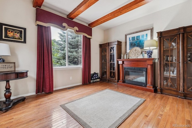 sitting room featuring beamed ceiling and light wood-type flooring