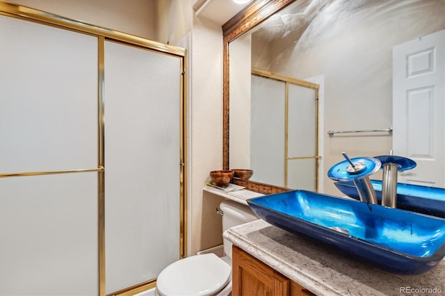 bathroom featuring vanity, walk in shower, and toilet