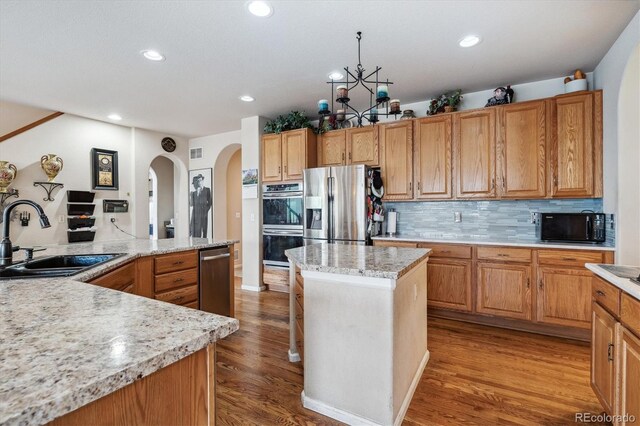 2891 Canyon Crest Dr, Highlands Ranch, CO 80126 - kitchen featuring recessed lighting, a center island, a sink, wood finished floors, and appliances with stainless steel finishes