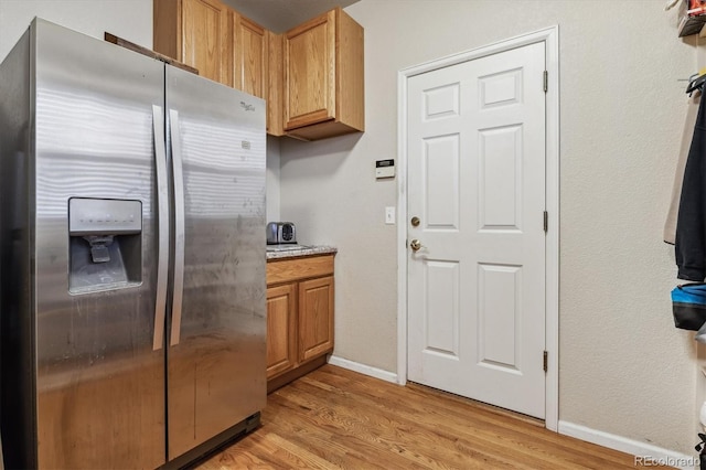 kitchen with light hardwood / wood-style floors and stainless steel fridge