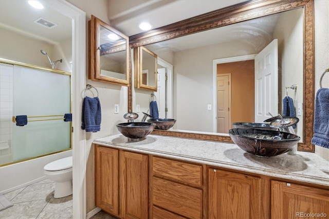 full bathroom featuring enclosed tub / shower combo, tile patterned floors, vanity, and toilet