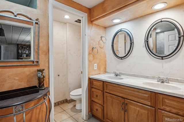 bathroom with dual vanity, toilet, and tile patterned flooring