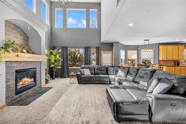 carpeted living room with recessed lighting, a fireplace, and an inviting chandelier