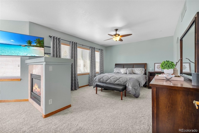 bedroom featuring carpet floors, baseboards, visible vents, and a tiled fireplace