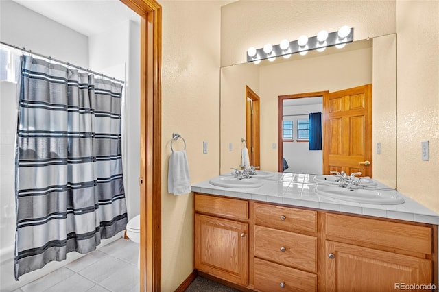 bathroom featuring double vanity, curtained shower, and a sink