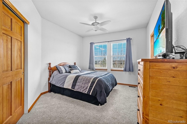 carpeted bedroom with ceiling fan and baseboards