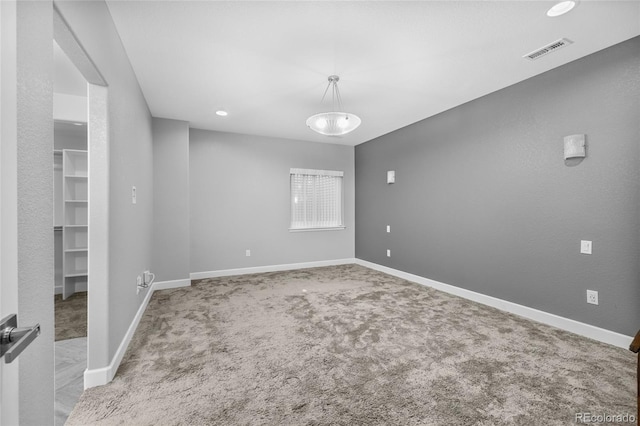 empty room featuring carpet floors, recessed lighting, visible vents, and baseboards