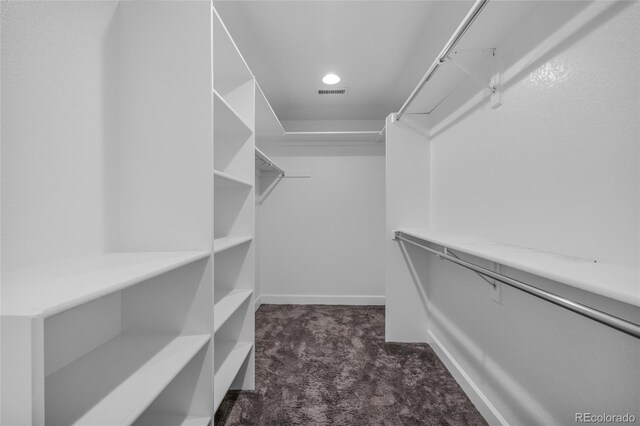 walk in closet with dark colored carpet and visible vents