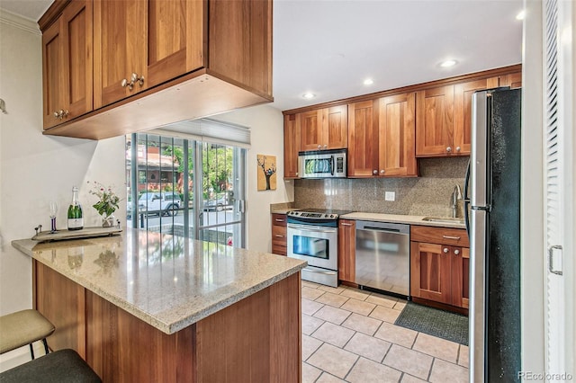 1200 N Humboldt St Unit 101, Denver, CO 80218 - kitchen featuring stainless steel appliances, a peninsula, backsplash, brown cabinets, and light tile patterned floors