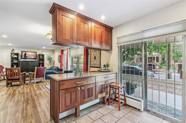 1200 N Humboldt St Unit 101, Denver, CO 80218 - kitchen featuring plenty of natural light, brown cabinetry, recessed lighting, light stone countertops, and light wood-type flooring