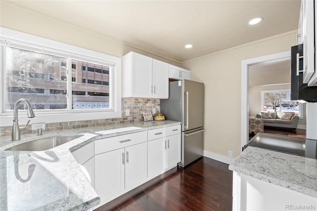 kitchen featuring white cabinetry, light stone countertops, sink, dark hardwood / wood-style flooring, and stainless steel fridge