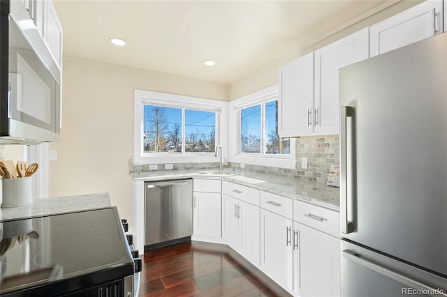 kitchen with sink, dark hardwood / wood-style floors, light stone countertops, white cabinetry, and stainless steel appliances