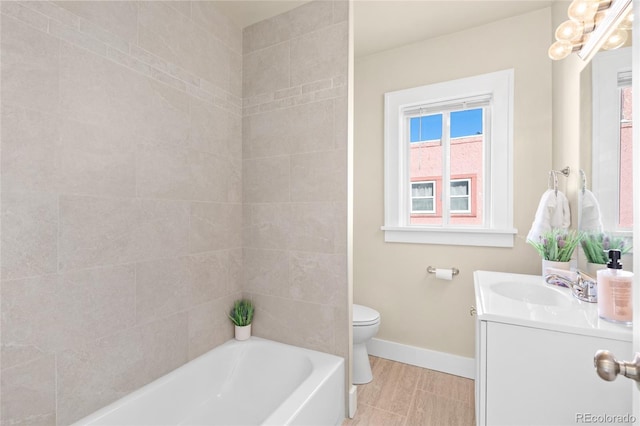 full bathroom with tiled shower / bath, vanity, and toilet