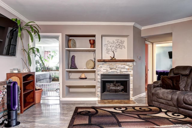 living room featuring ornamental molding, built in features, wood finished floors, a fireplace, and baseboards