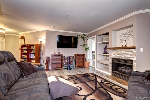 living room with built in features, ornamental molding, wood finished floors, and a fireplace