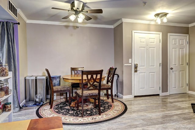 dining room with light wood-style floors, baseboards, ceiling fan, and visible vents