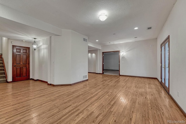 spare room with visible vents, light wood finished floors, and baseboards