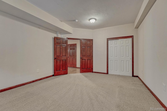 unfurnished bedroom featuring baseboards and light carpet