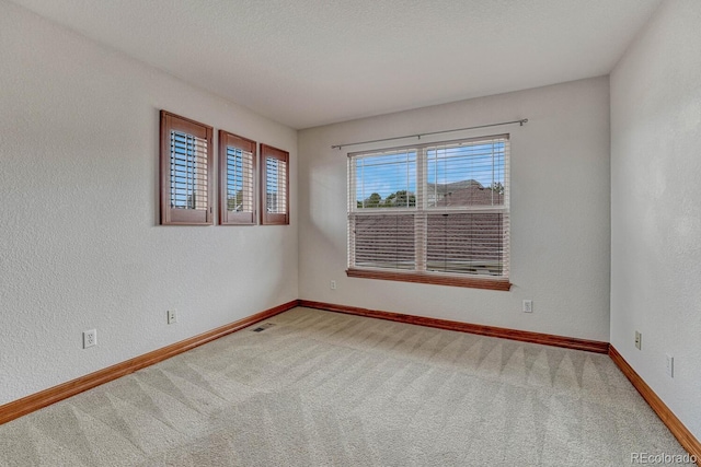 carpeted empty room with baseboards and visible vents