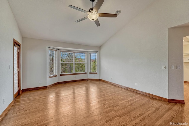 unfurnished room with visible vents, lofted ceiling, baseboards, a ceiling fan, and light wood-style flooring