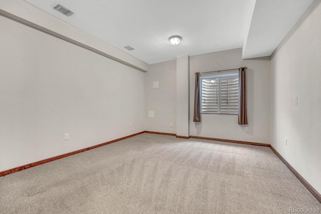 unfurnished room featuring baseboards, light carpet, and visible vents
