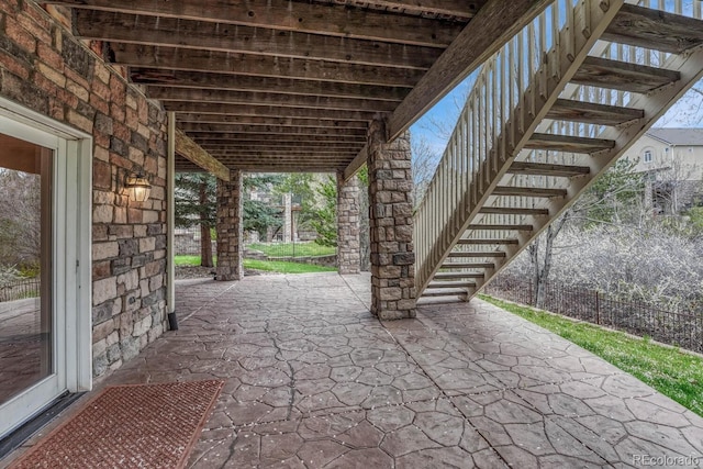 view of patio with fence and stairs