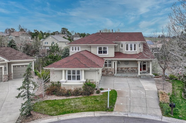 mediterranean / spanish house featuring a porch, a garage, concrete driveway, stone siding, and stucco siding