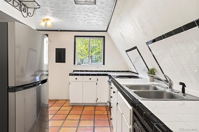 779 High Point Cir, Black Hawk, CO 80422 - kitchen with freestanding refrigerator, tile countertops, a sink, white cabinets, and light tile patterned floors