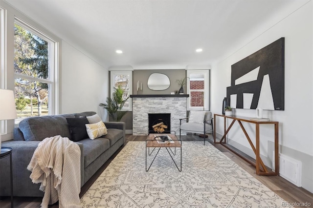 living room with a fireplace, visible vents, wood finished floors, and recessed lighting