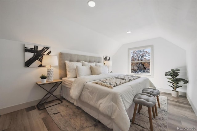 bedroom with vaulted ceiling, recessed lighting, wood finished floors, and baseboards