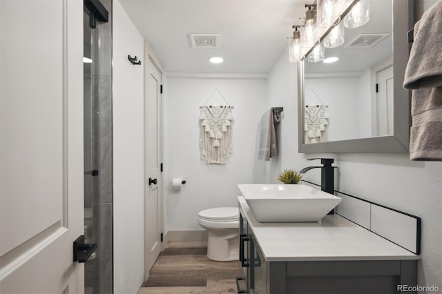 full bathroom featuring toilet, wood finished floors, vanity, and visible vents