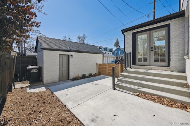 view of patio with a fenced backyard, an outbuilding, and french doors