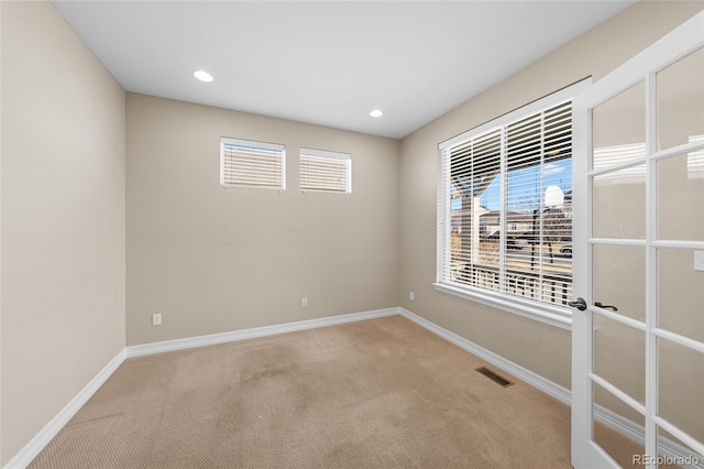 unfurnished room with visible vents, french doors, carpet, and baseboards