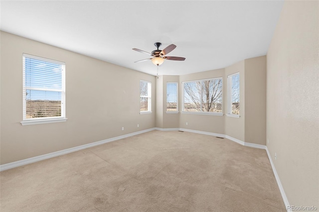 unfurnished room featuring baseboards, light carpet, and ceiling fan