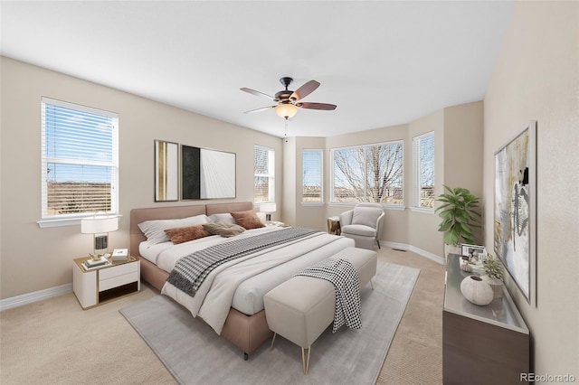 bedroom with light colored carpet, baseboards, and ceiling fan