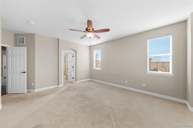 unfurnished bedroom featuring visible vents, ceiling fan, baseboards, light carpet, and ensuite bathroom