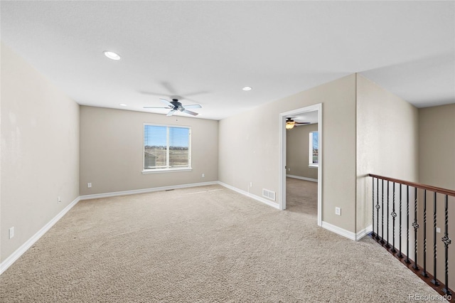 carpeted spare room with visible vents, recessed lighting, a ceiling fan, and baseboards