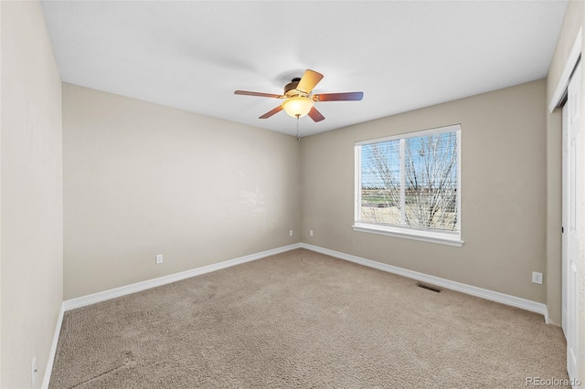 unfurnished bedroom with a ceiling fan, visible vents, carpet, and baseboards